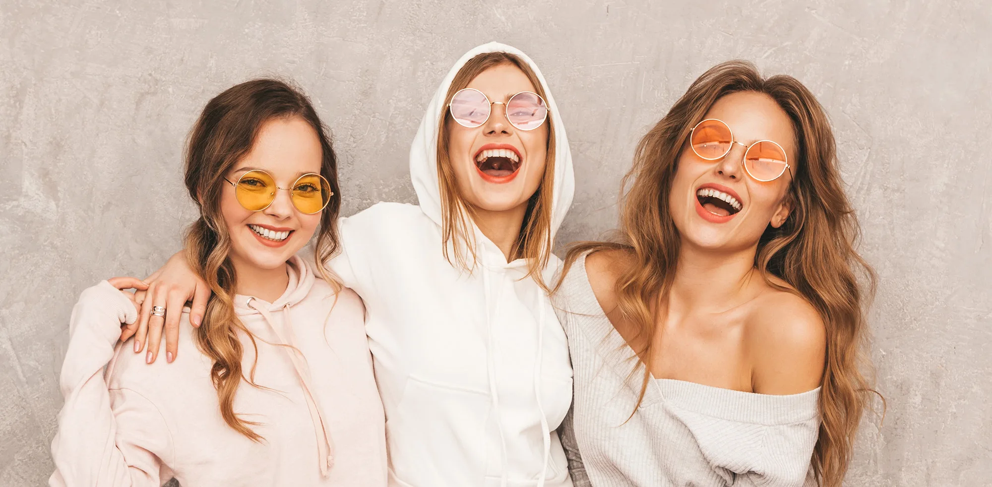 Three girls in sunglasses posing for photo