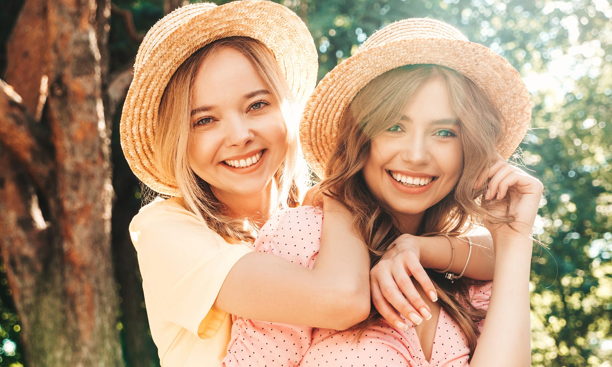 Two women with hats posing outdoors