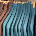 Row of sweaters on a clothes rack.