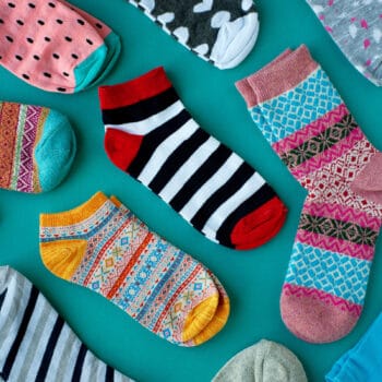Multiple pairs of different colored socks on a blue background.