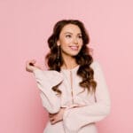 Woman in pink top on pink background.