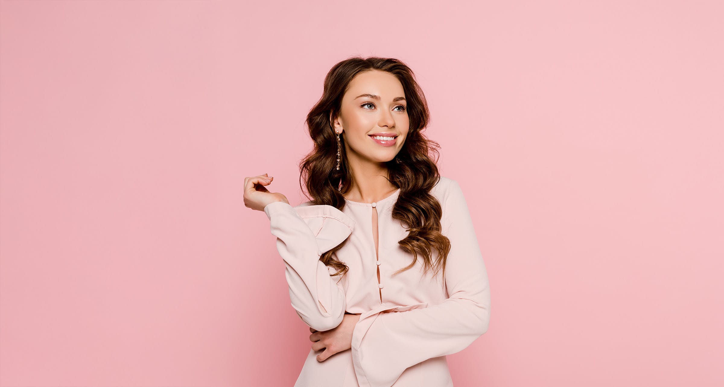 Woman in pink top on pink background.