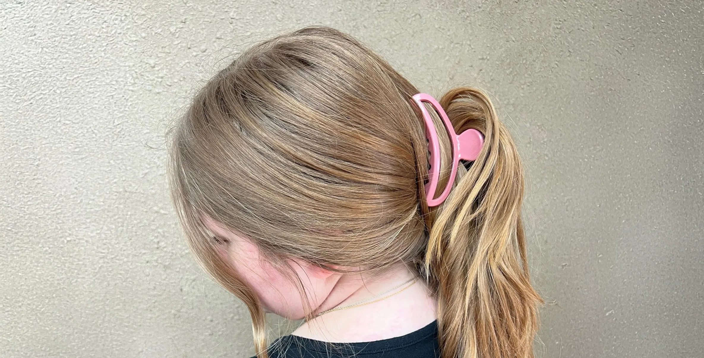 Girl with pink crescent shaped jaw clip in her hair.