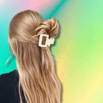 Blonde hair styled in a half-up twist secured with a matte cream rectangular claw clip against a soft gradient background.